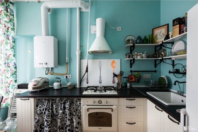 Balto vandens šildytuvas ir baltas gaubtas mėlynos virtuvės viduje retro stiliaus