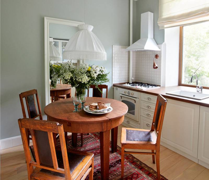 Kulatý malý dřevěný stůl v interiéru malé kuchyně