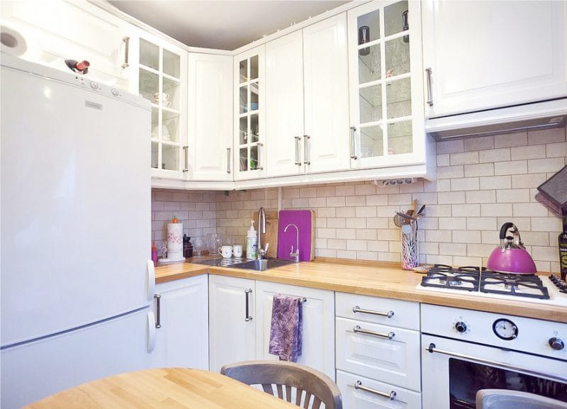 Virtuvė su violetiniais priedais ir užuolaidomis
