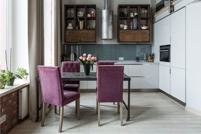 Kuhinja u stilu potkrovlja s ljubičastim tapeciranim stolicama