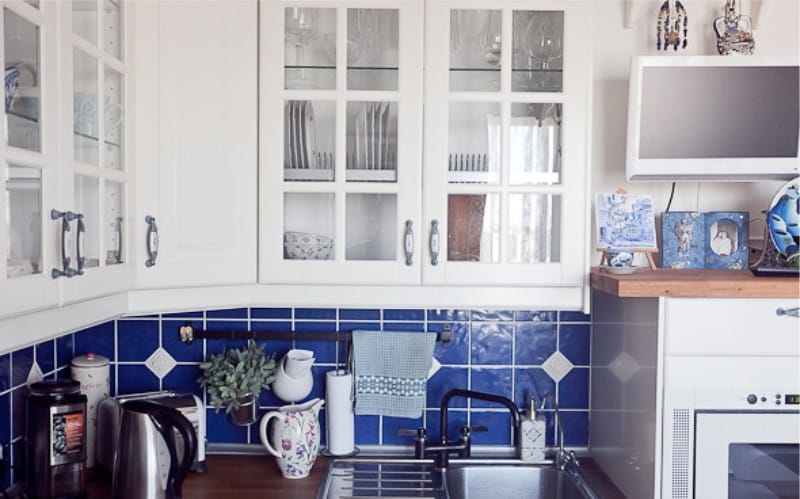 Interiør av hvitt og blått kjøkken med Gzhel malte retter