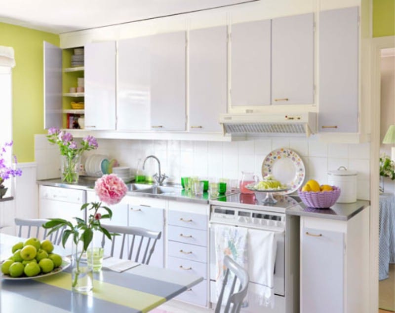 Cocina de color lila claro con una pared verde en el interior.