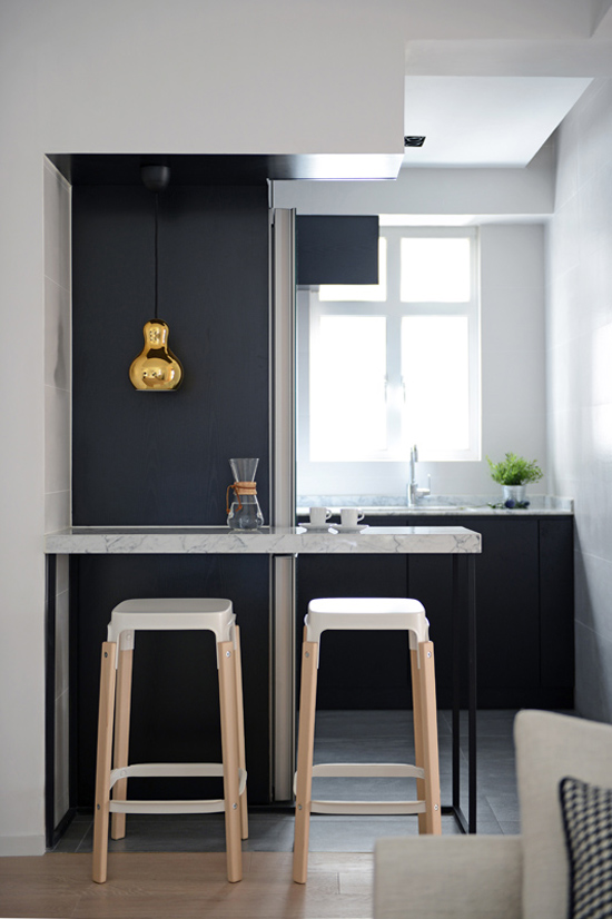 Златна лампа у црно-белој кухињи