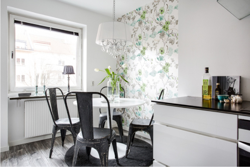Black and white kitchen with white wallpaper with green and blue colors.